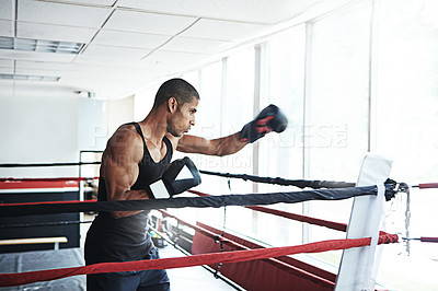 Buy stock photo Shot of a young man training in a boxing ring