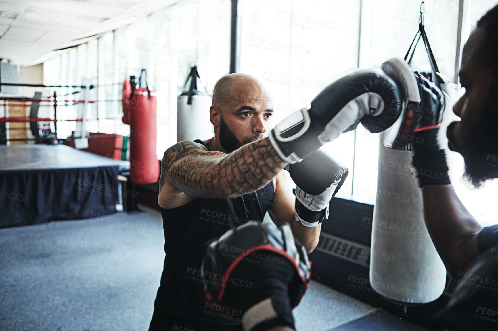 Buy stock photo Shot of a male boxer practising his moves with his coach