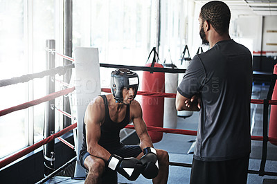 Buy stock photo Shot of a man training in the boxing ring with a coach