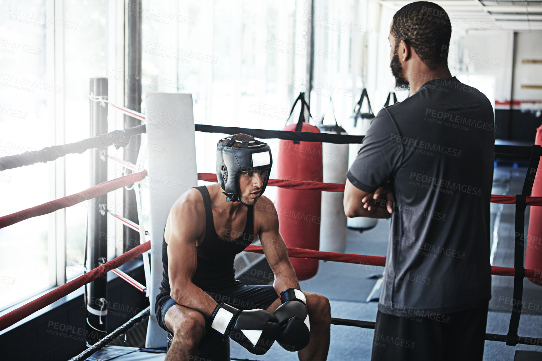 Buy stock photo Shot of a man training in the boxing ring with a coach