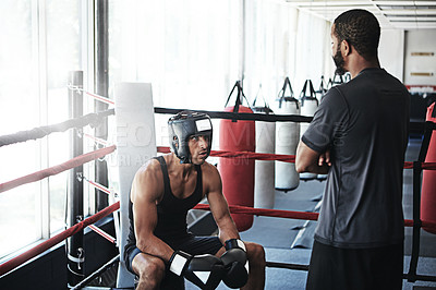 Buy stock photo Shot of a man training in the boxing ring with a coach