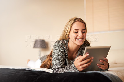 Buy stock photo Cropped shot of an attractive young woman using a digital tablet at home