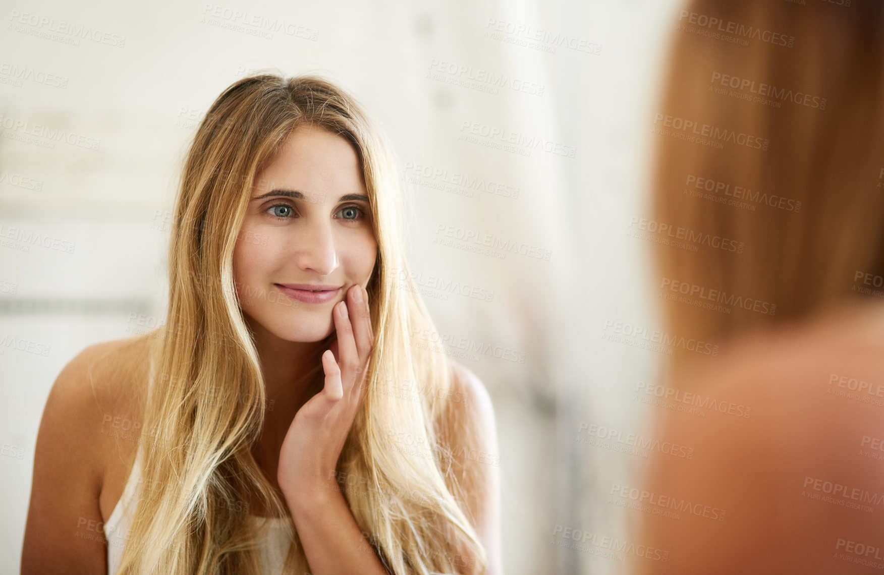 Buy stock photo Shot of a young woman admiring her perfect skin in the mirror at home