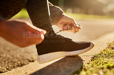 Buy stock photo Shot of an unidentifiable young woman tying her shoelace before going on a run