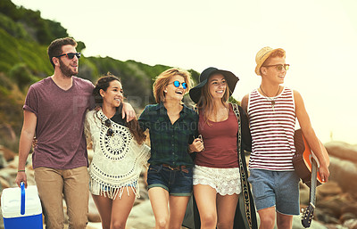 Buy stock photo Cropped shot of a group of friends walking on the beach on a summer's day