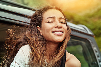 Buy stock photo Cropped shot of a young woman leaning out the window of a car while on a roadtrip