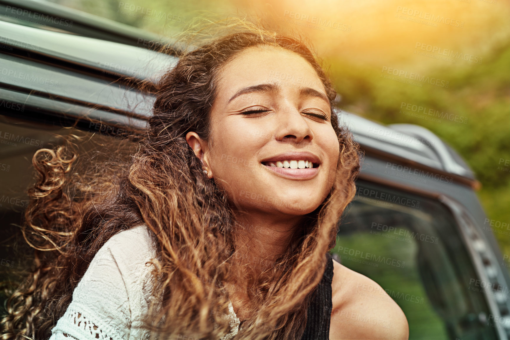 Buy stock photo Cropped shot of a young woman leaning out the window of a car while on a roadtrip