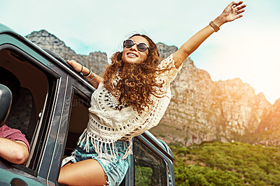 Buy stock photo Cropped shot of a young woman leaning out a car with her arms outstretched while on a roadtrip