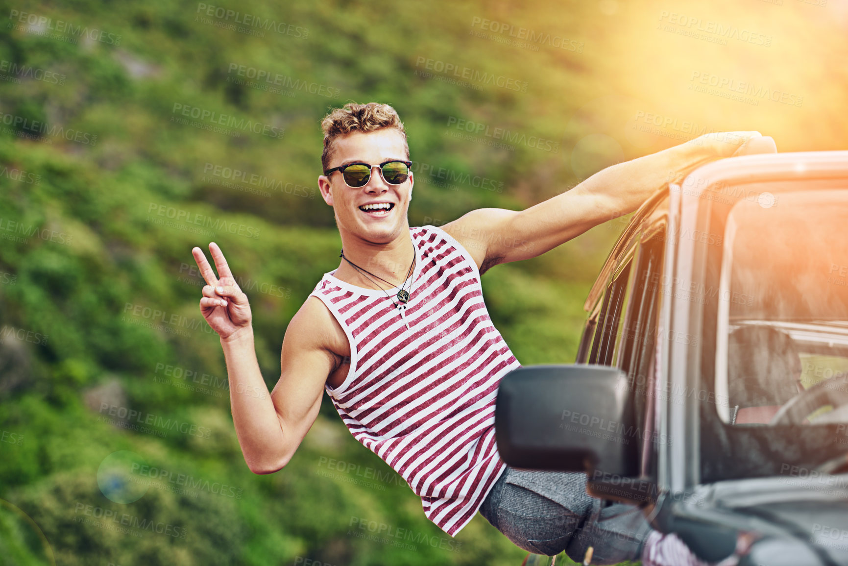 Buy stock photo Portrait of a young man leaning out the window of a car while on a roadtrip