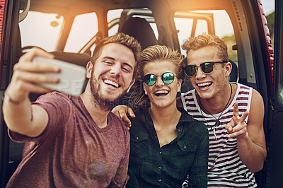 Buy stock photo Cropped shot of a group of friends taking a selfie while on a roadtrip together