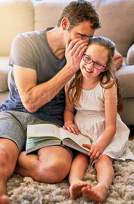 Buy stock photo Cropped shot of a father whispering in his little daughter's ear at home