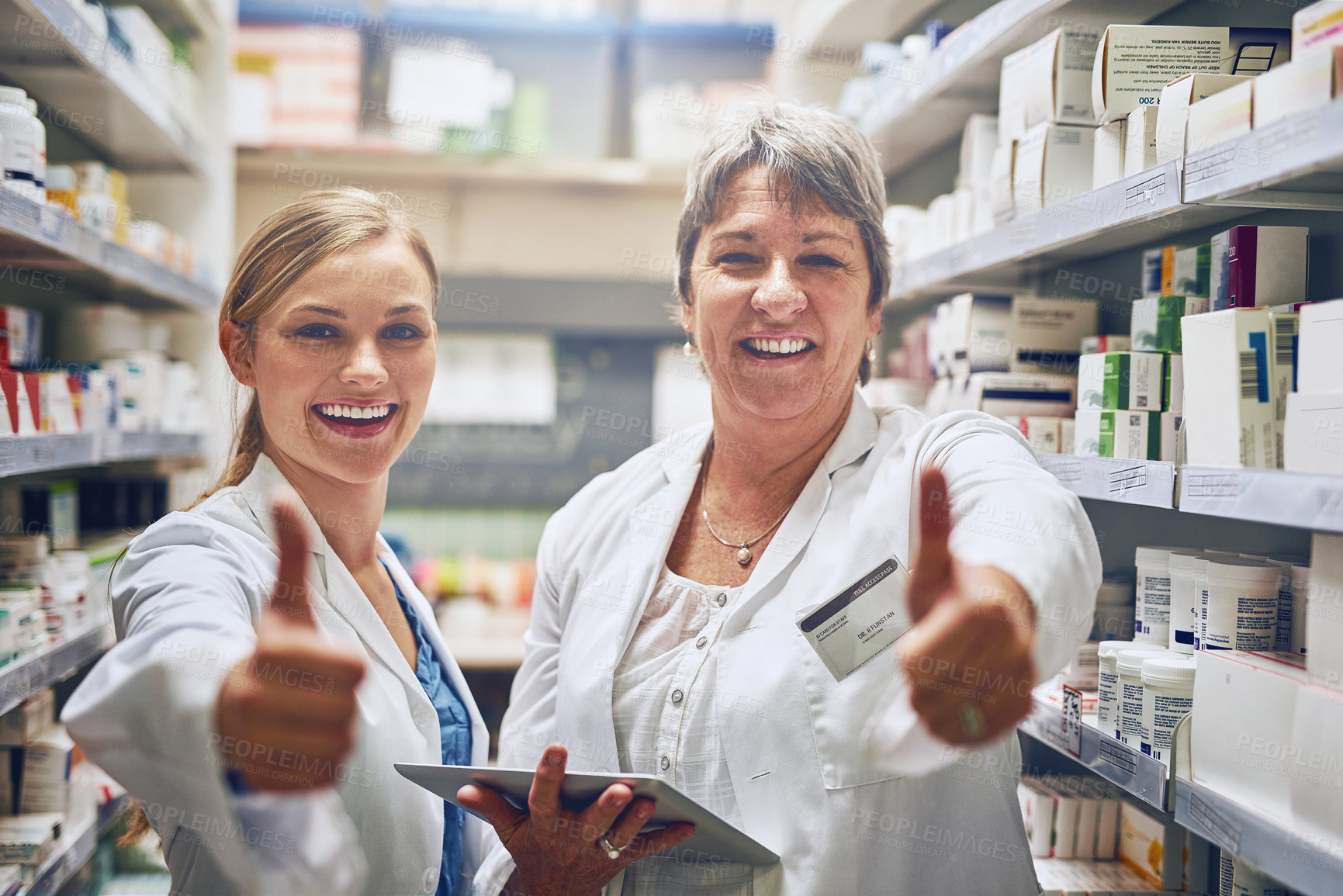Buy stock photo Shot of pharmacists showing thumbs up in a isle