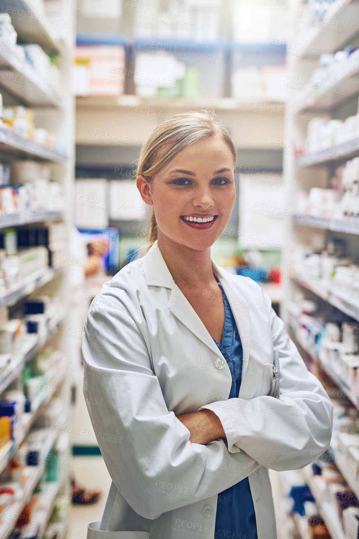 Buy stock photo Portrait of a pharmacist standing in a isle with her arms crossed