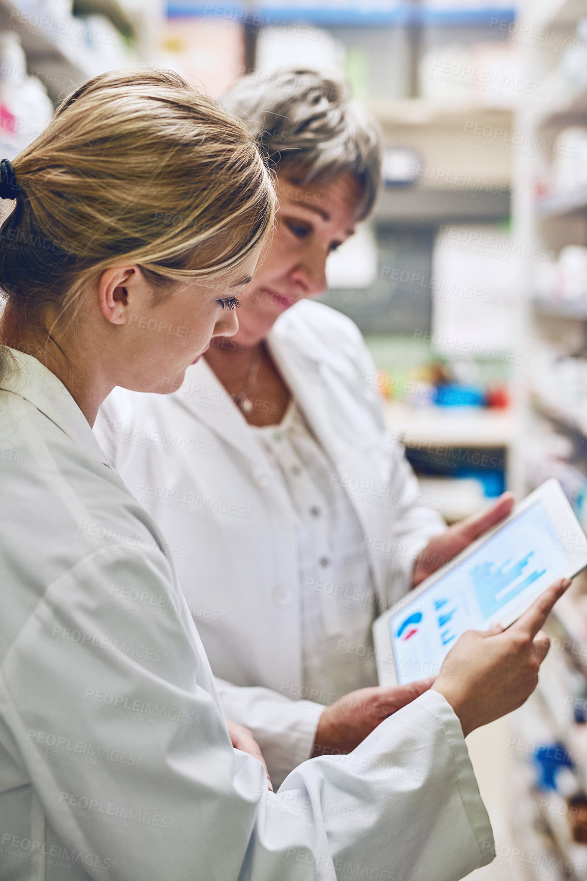 Buy stock photo Shot of pharmacists using a digital tablet together