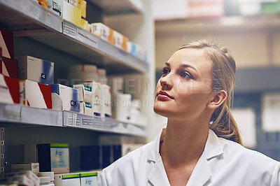 Buy stock photo Shot of an attractive young woman working in a pharmacy