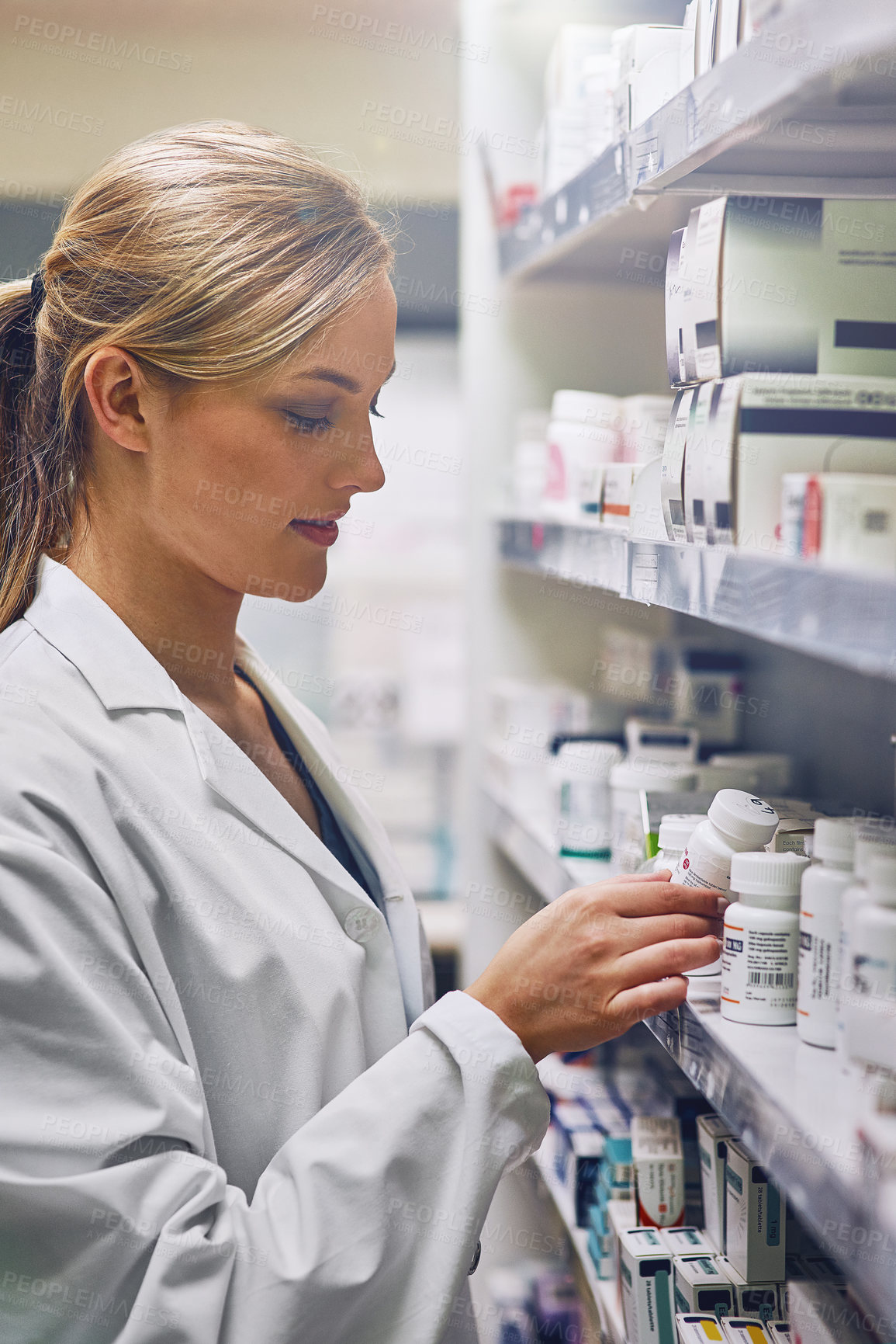 Buy stock photo Shot of an attractive young woman working in a pharmacy
