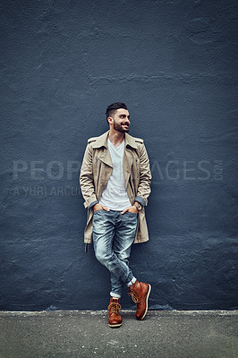Buy stock photo Shot of a fashionable young man wearing urban wear and posing against a gray wall