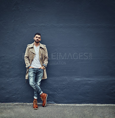 Buy stock photo Portrait of a fashionable young man wearing urban wear and posing against a gray wall