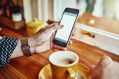 Buy stock photo Cropped closeup shot of a young man reading a text message while sitting at a counter in a cafe