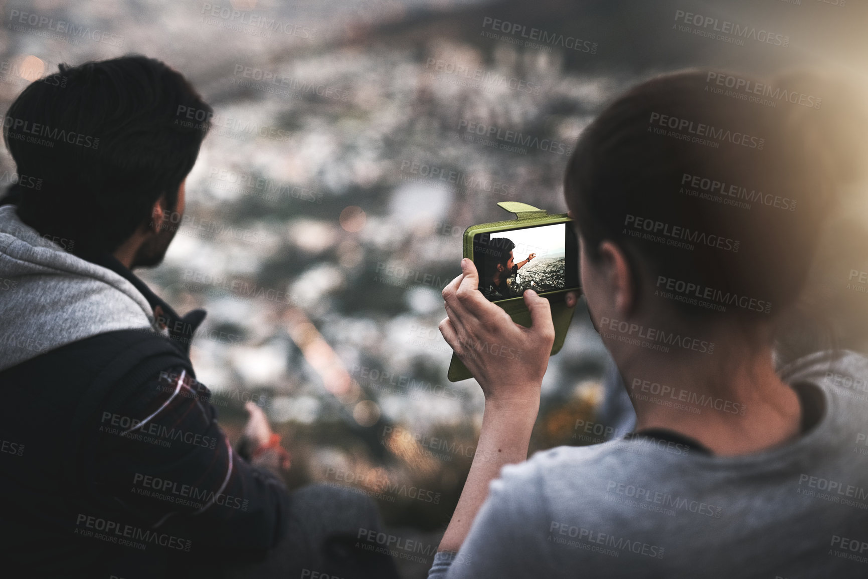 Buy stock photo Rearview shot of a young couple taking photographs of the view while mountain hiking