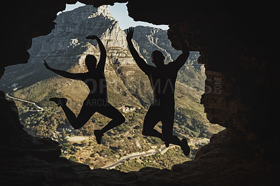 Buy stock photo Rearview shot of a young couple jumping in excitement while hiking in the mountains