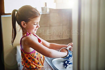Buy stock photo Cropped shot of a little girl washing dishes at home