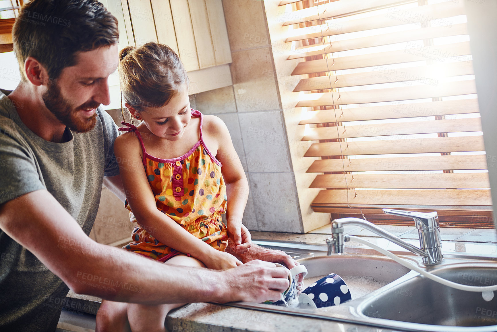 Buy stock photo Cropped shot of a father and his little daughter washing dishes together at home