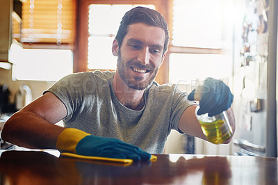 Buy stock photo Cropped shot of a young man cleaning a kitchen surface at home