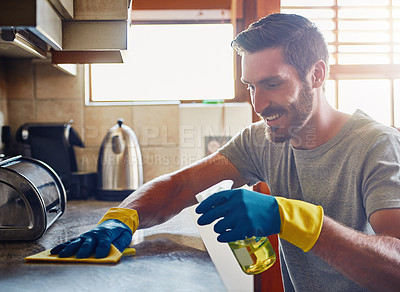 Buy stock photo Cropped shot of a young man cleaning a kitchen surface at home