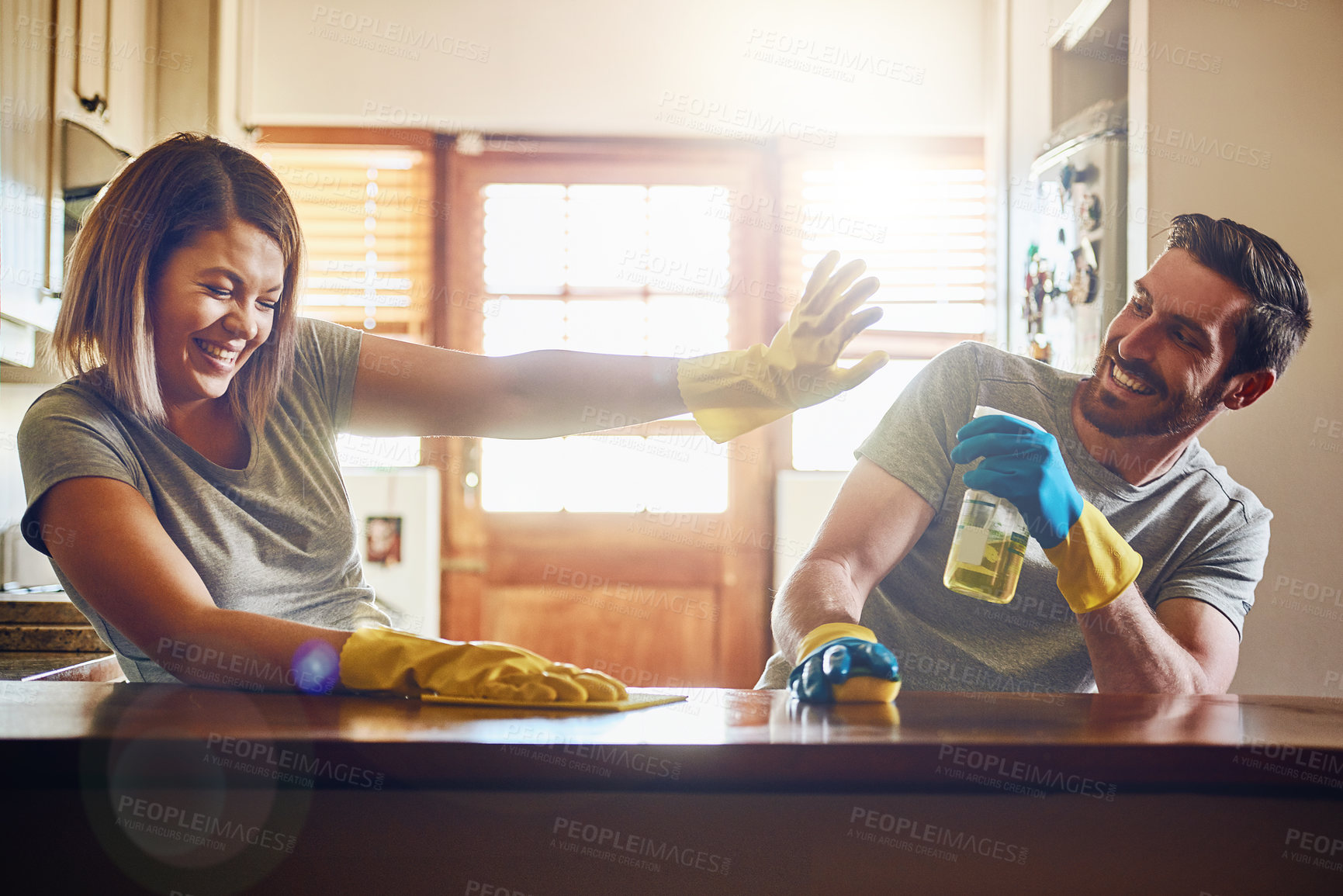 Buy stock photo Cropped shot of a young couple having fun while doing chores together at home