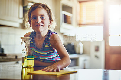 Buy stock photo Portrait of a little girl cleaning a kitchen surface at home