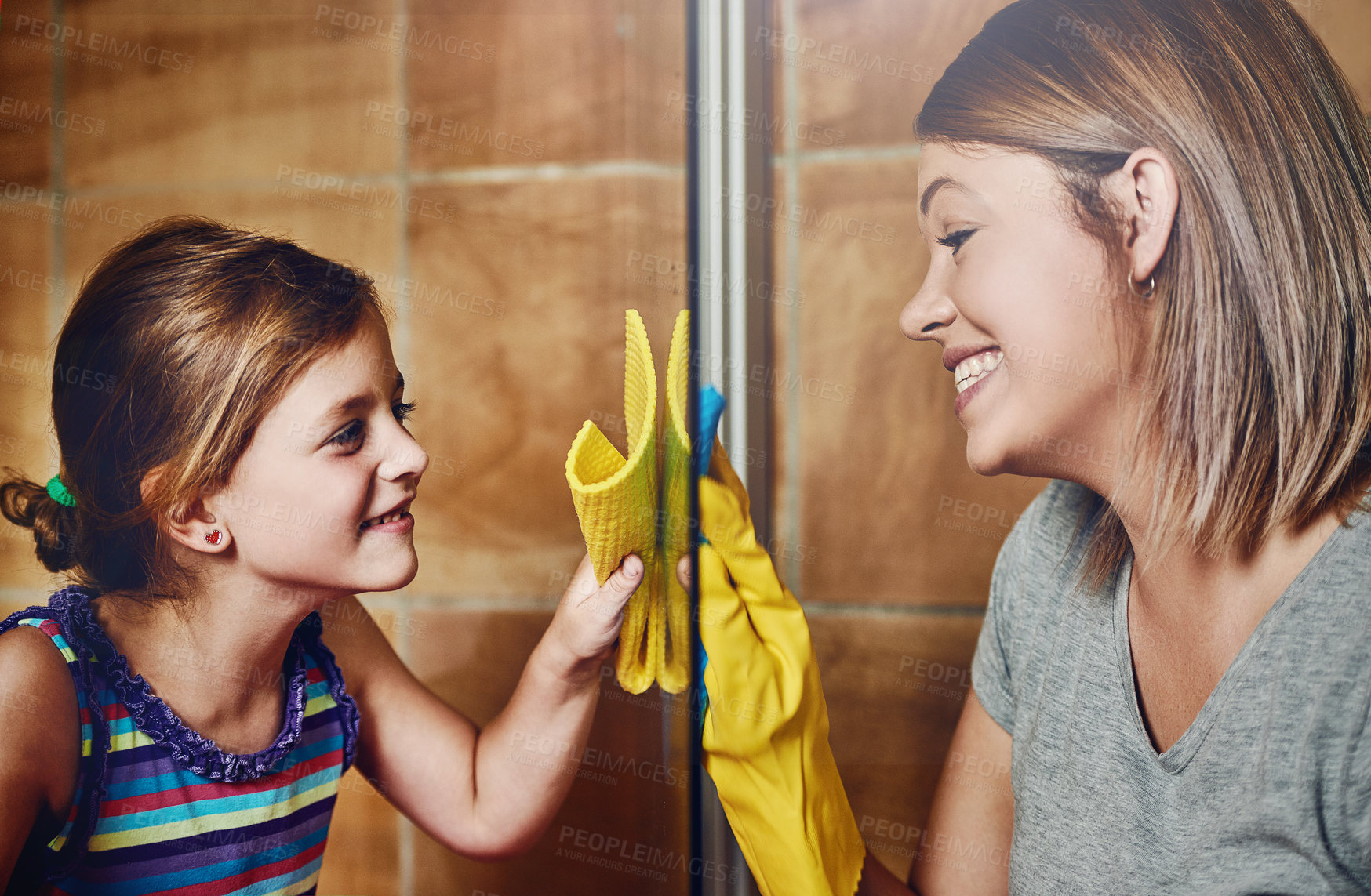 Buy stock photo Cropped shot of a mother and her little daughter cleaning a bathroom together at home