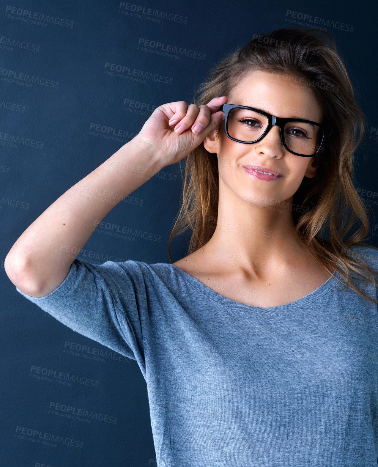 Buy stock photo Studio portrait of a cute teenage girl in glasses posing against a dark background