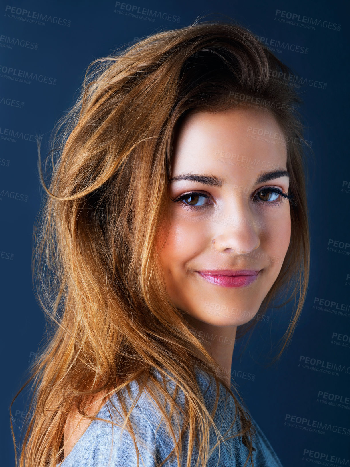 Buy stock photo Studio portrait of a cute teenage girl smiling and posing against a dark background