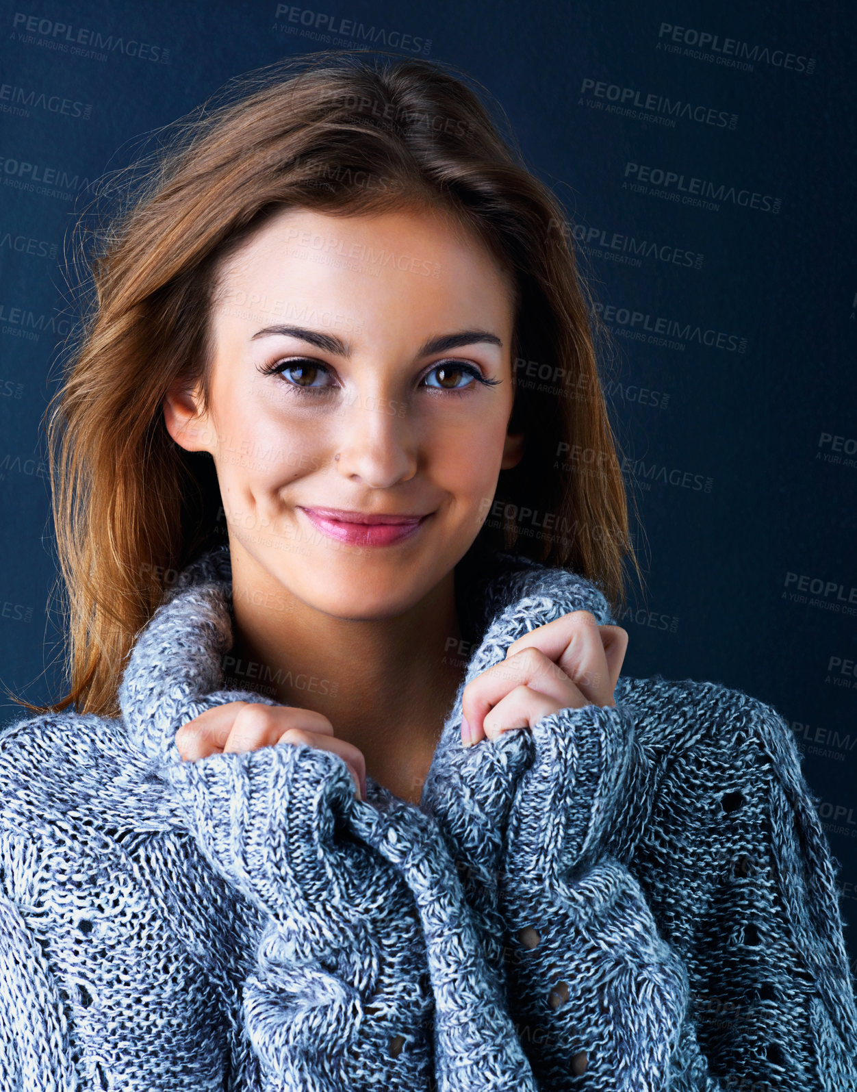 Buy stock photo Studio portrait of a cute teenage girl in a sweater posing against a dark background