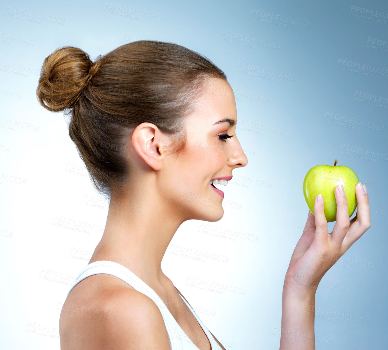 Buy stock photo Shot of a health-conscious young woman posing with an apple in studio