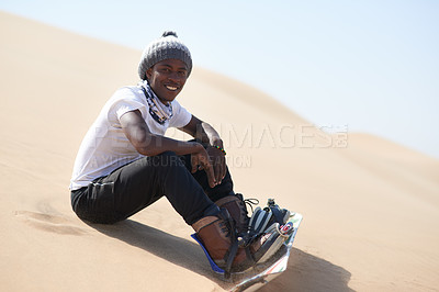 Buy stock photo Portrait of a young man sandboarding in the desert