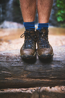 Buy stock photo Shot of an unidentifiable hiker standing on a log in the jungle