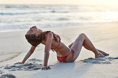 Buy stock photo Shot of a beautiful young woman sitting on the beach