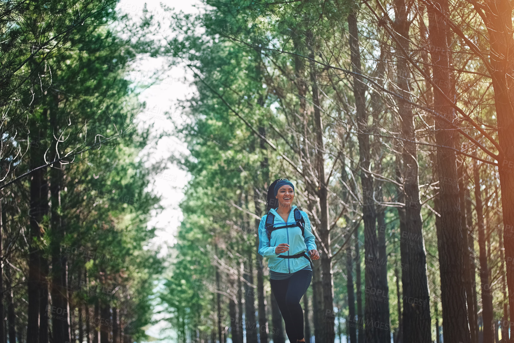 Buy stock photo Cropped shot of an athletic young woman out for a jog in the woods