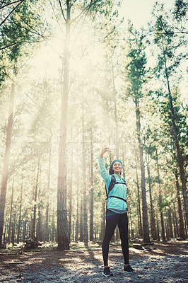 Buy stock photo Full length shot of an athletic young woman taking selfies while jogging in the woods