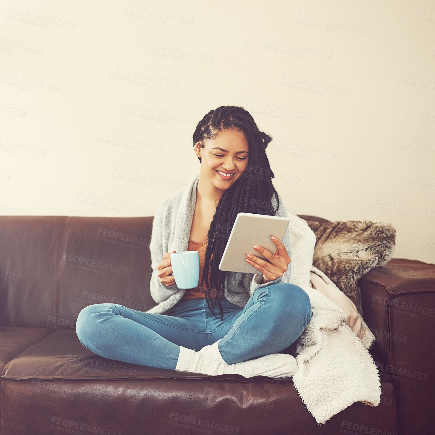 Buy stock photo Shot of a young woman relaxing at home with a cup of coffee and a digital tablet