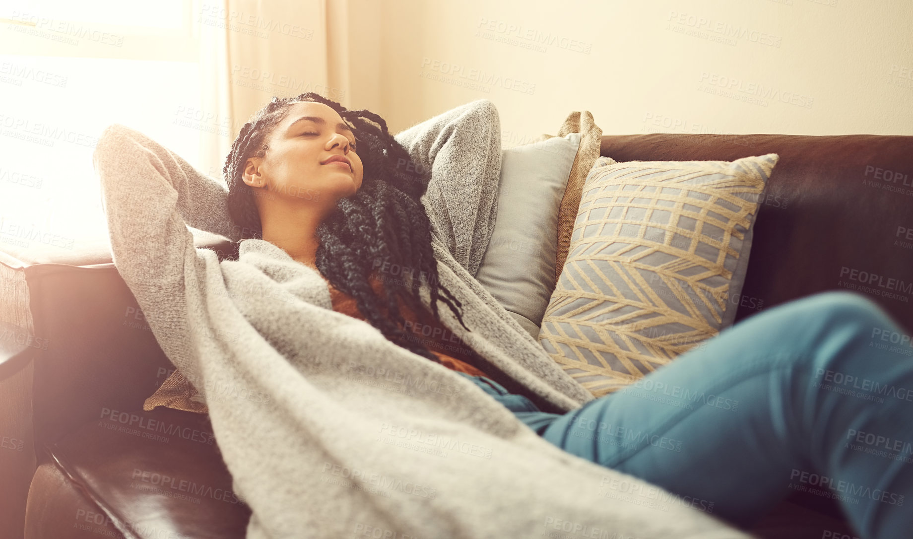 Buy stock photo Shot of a young woman sleeping on her living room sofa