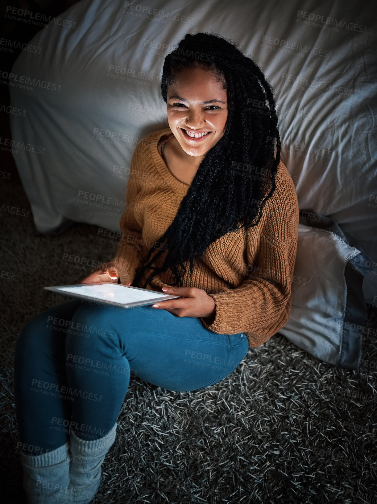 Buy stock photo Shot of a relaxed young woman using a digital tablet during the evening at home