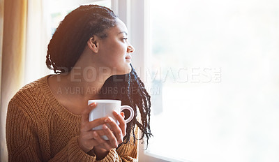 Buy stock photo Shot of a young woman enjoying a cup of coffee at home