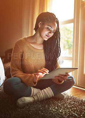 Buy stock photo Shot of a relaxed young woman using a digital tablet at home