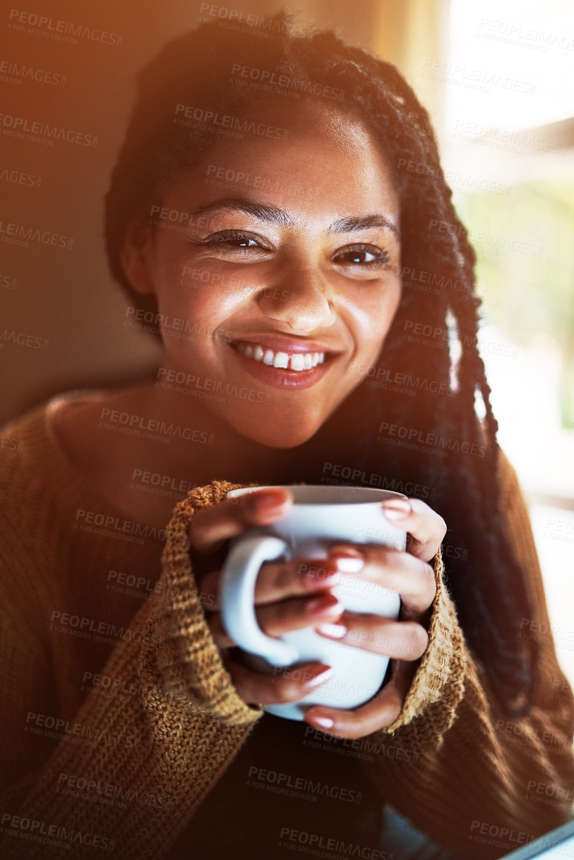 Buy stock photo Portrait of a happy young woman relaxing with a warm beverage at home