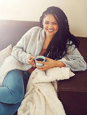 Buy stock photo Shot of a young woman enjoying a cup of coffee in her living room