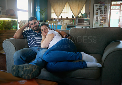 Buy stock photo Shot of a loving pregnant couple relaxing on the couch together at home