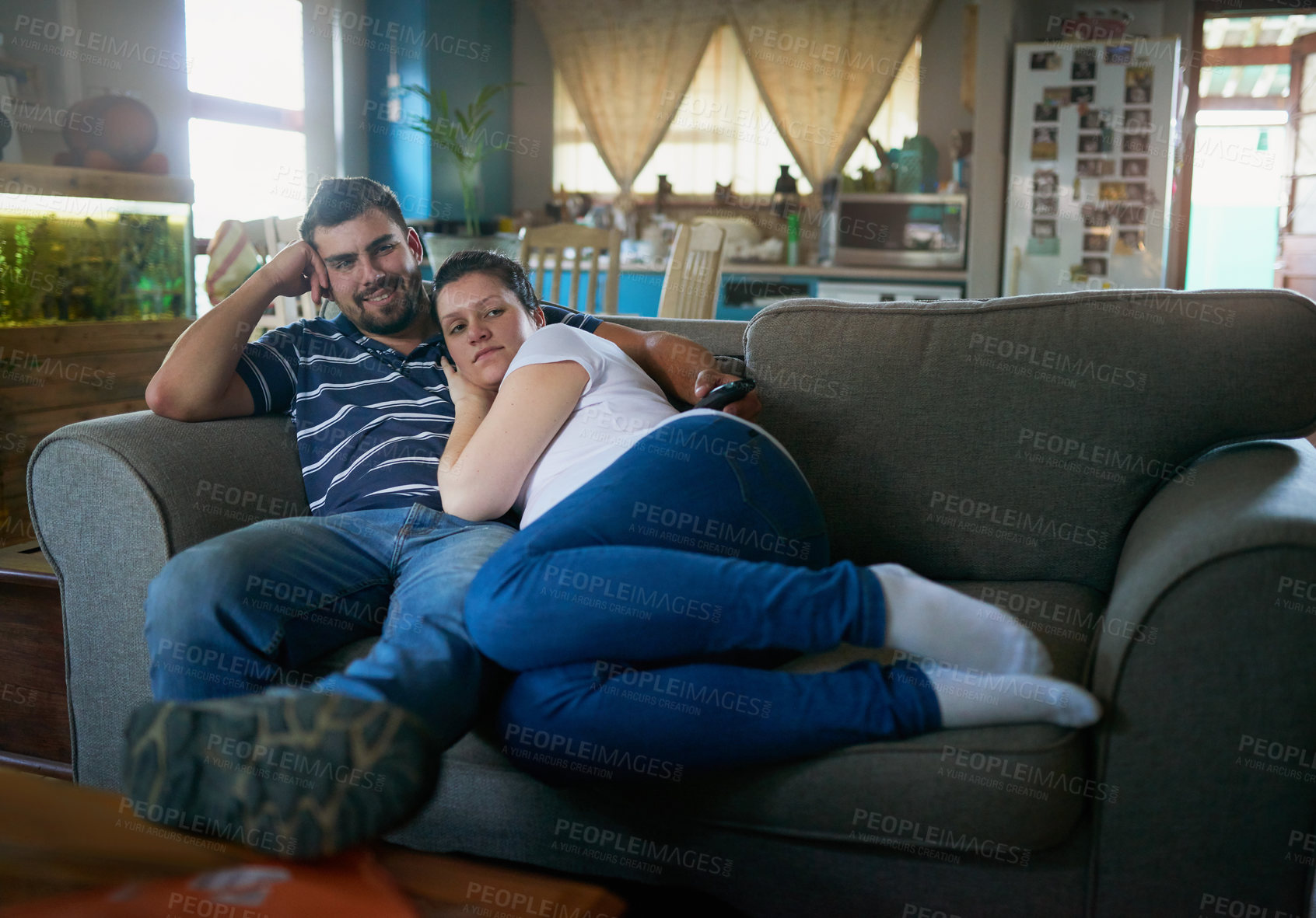 Buy stock photo Shot of a loving pregnant couple relaxing on the couch together at home